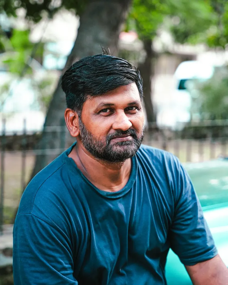 Portrait of driving instructor Bilal Ahmed in a teal t-shirt